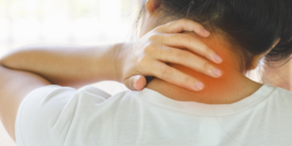 Woman holding her hand on back of painful, tight neck